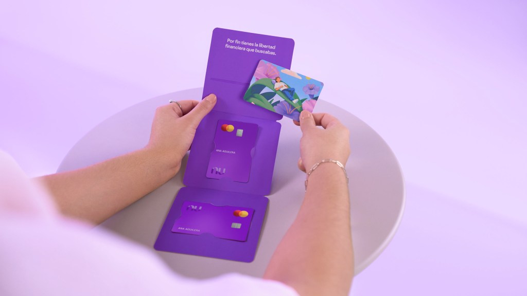 Persona sosteniendo múltiples tarjetas moradas Nu con diferentes diseños personalizados, ilustrando que solicitar una reposición de tarjeta de crédito Nu es sencillo y sin costo.