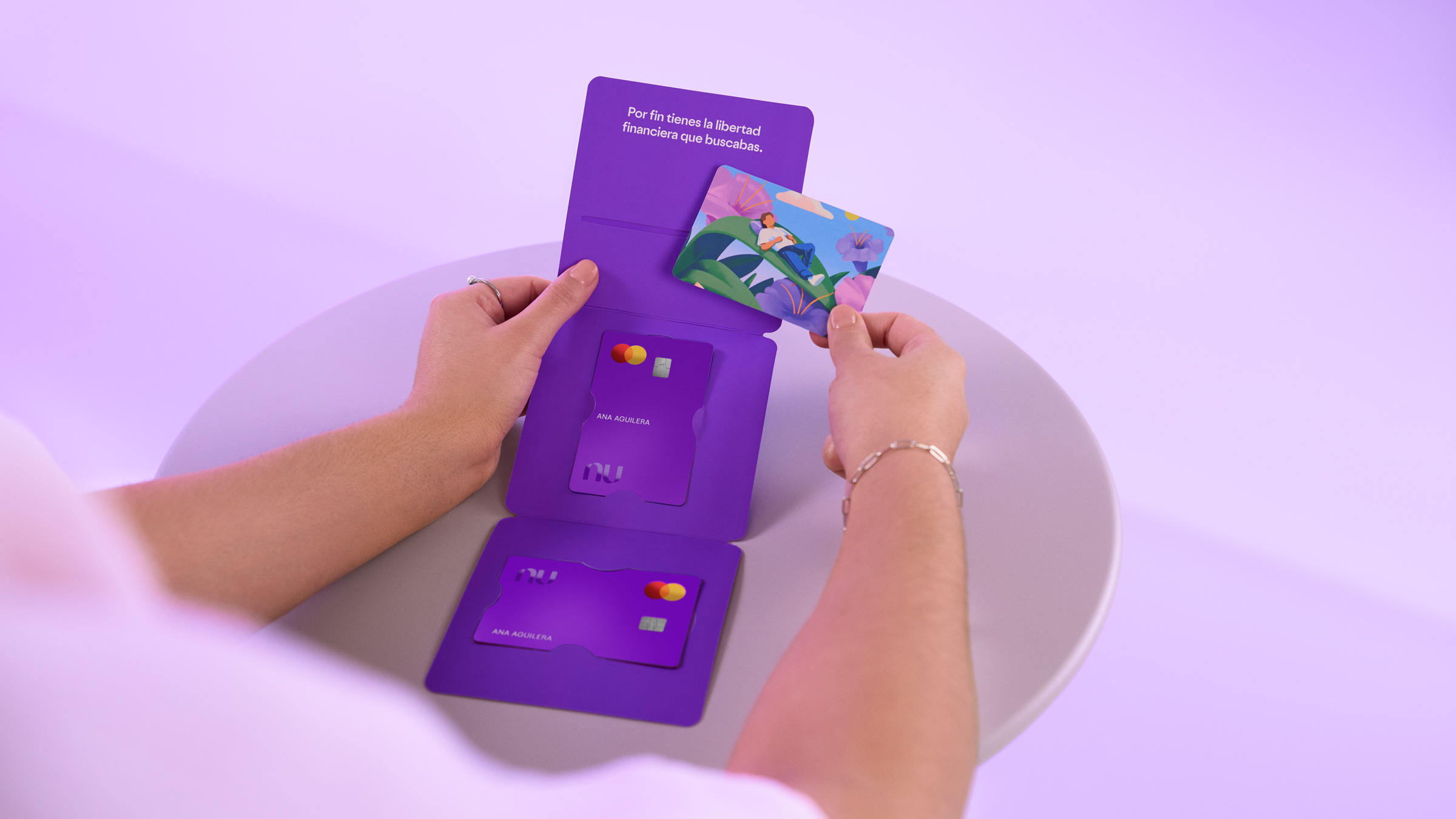 Persona sosteniendo múltiples tarjetas moradas Nu con diferentes diseños personalizados, ilustrando que solicitar una reposición de tarjeta de crédito Nu es sencillo y sin costo.