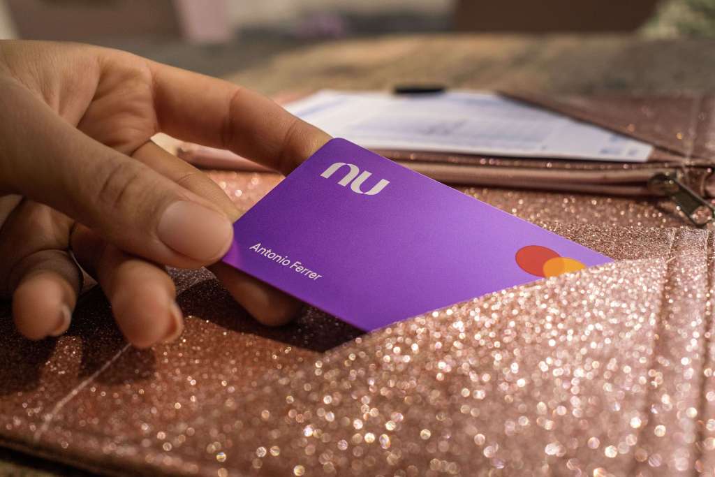 Fotografía de una mano sosteniendo la tarjeta de crédito Nu. Descubre la App Nu.