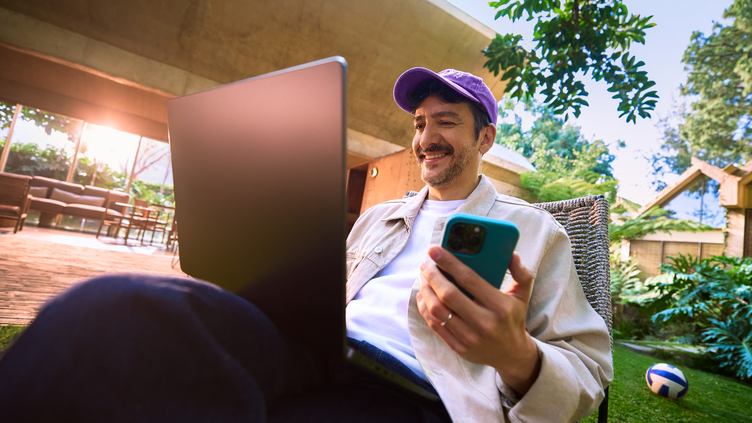 Hombre relajado en su jardín usando su celular, representando lo sencillo que es gestionar y cancelar tu Tarjeta de Crédito Nu desde cualquier lugar.