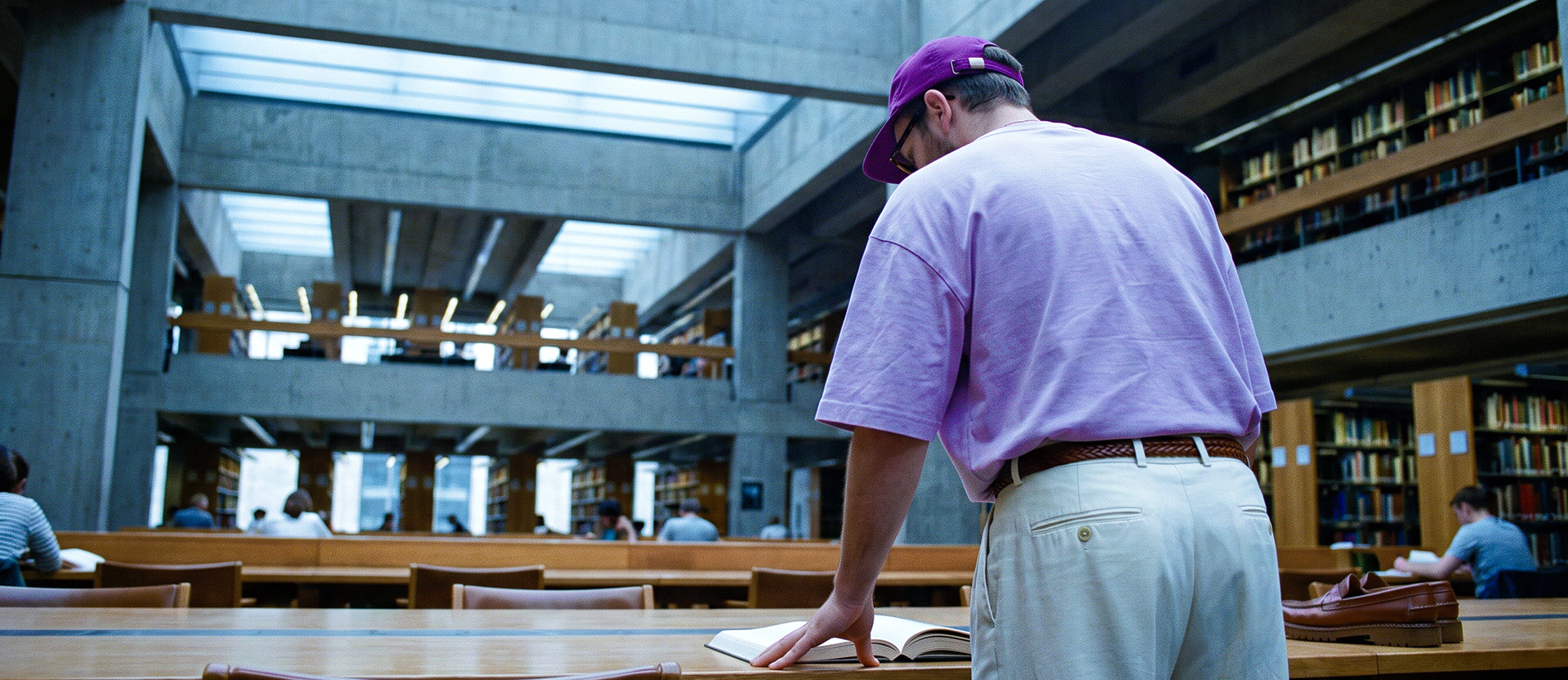 Persona con camisa morada estudiando en una biblioteca con libros y estanterías, ilustrando cómo entender qué es banca múltiple: la estructura legal y regulatoria de los bancos en México bajo supervisión de CNBV y Banxico.