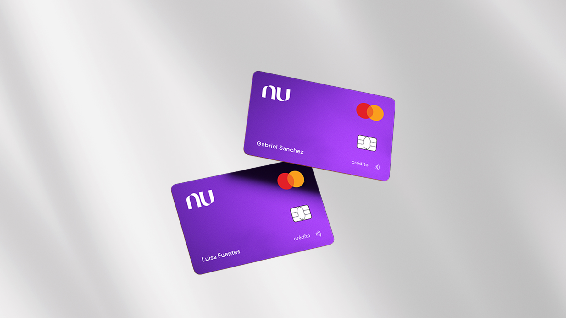 Dos tarjetas de crédito de color morado están suspendidas en el aire frente a un fondo color gris para recordar cómo funciona la tarjeta garantizada nu