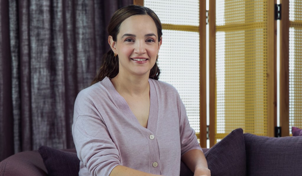 Paulina Juaristi head of marketing para nu méxico viste una blusa morada y sonríe sentada en un sillón color café