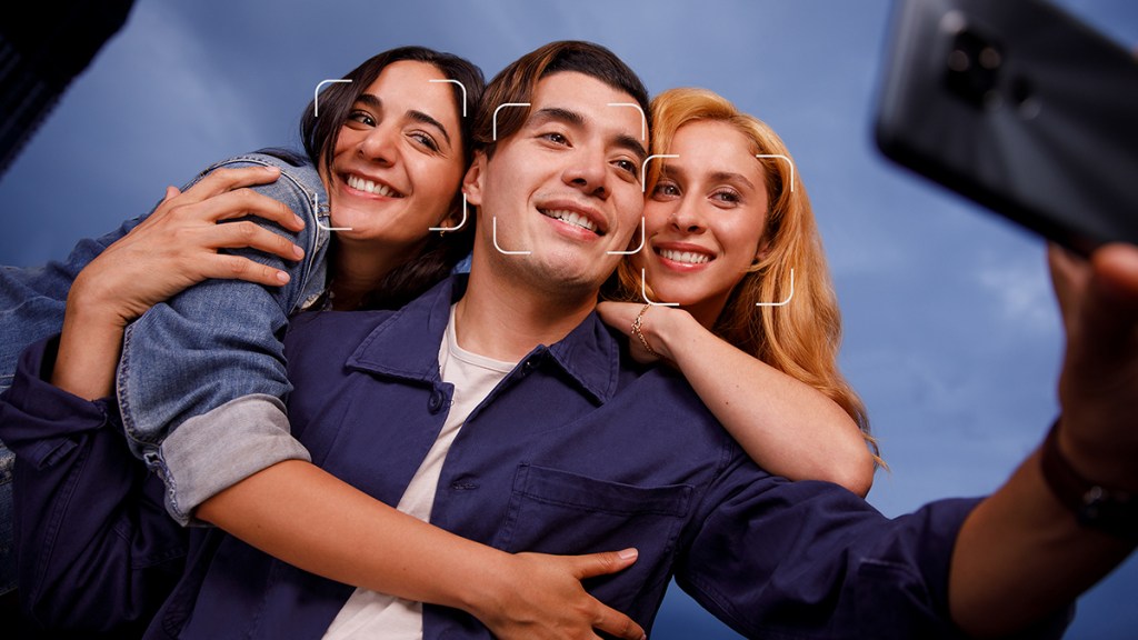 Tres jóvenes de edad mediana y es trigueña se abrazan sonriendo para una fotografía mientras visten prendas de color azul y se preguntan cómo saber quién tiene mis fotos en internet