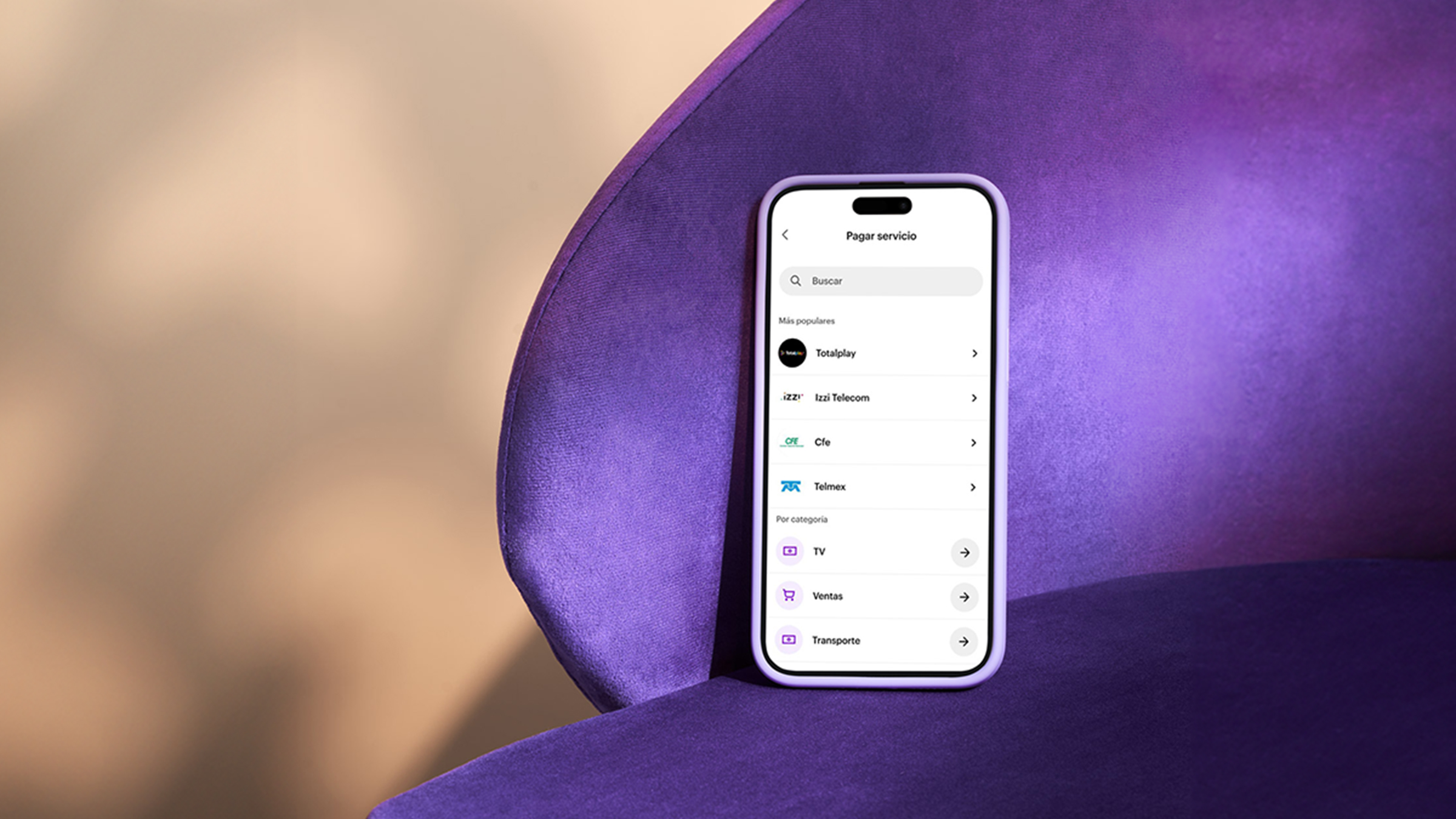 Un celular de color negro recargado en una silla color morado muestra varios íconos en su pantalla dentro de la pp nu para anunciar que ya se puede servicios con cuenta nu