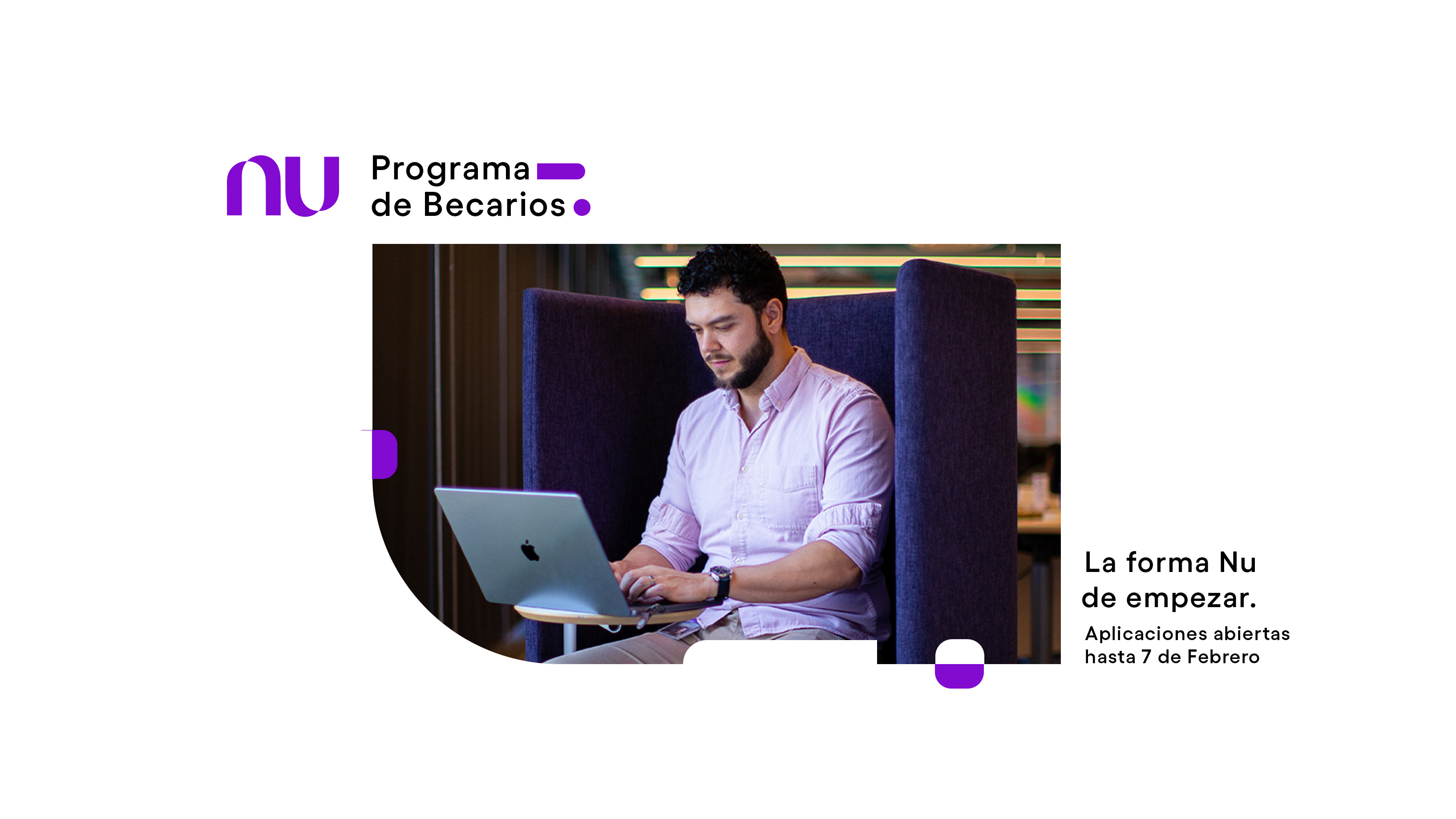 Un chico becario de edad mediana con una camisa color lila escribe en una computadora abierta dentro de las oficinas de Nu México en un escritorio de madera clara