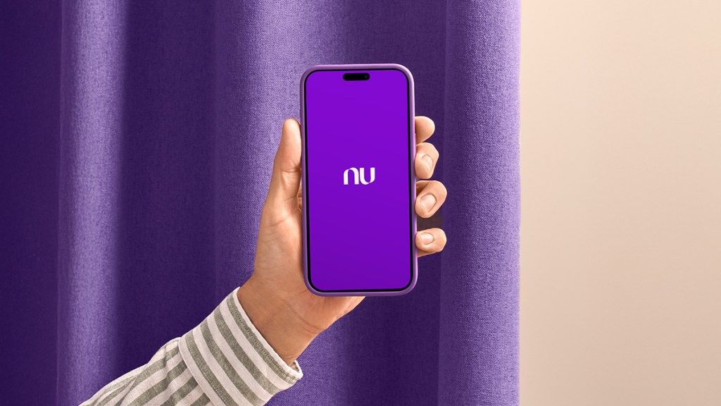 Una mano sostiene un teléfono móvil con la aplicación nu abierta en la pantalla de inicio para demostrar si es posible tener la app de Nu sin tarjeta