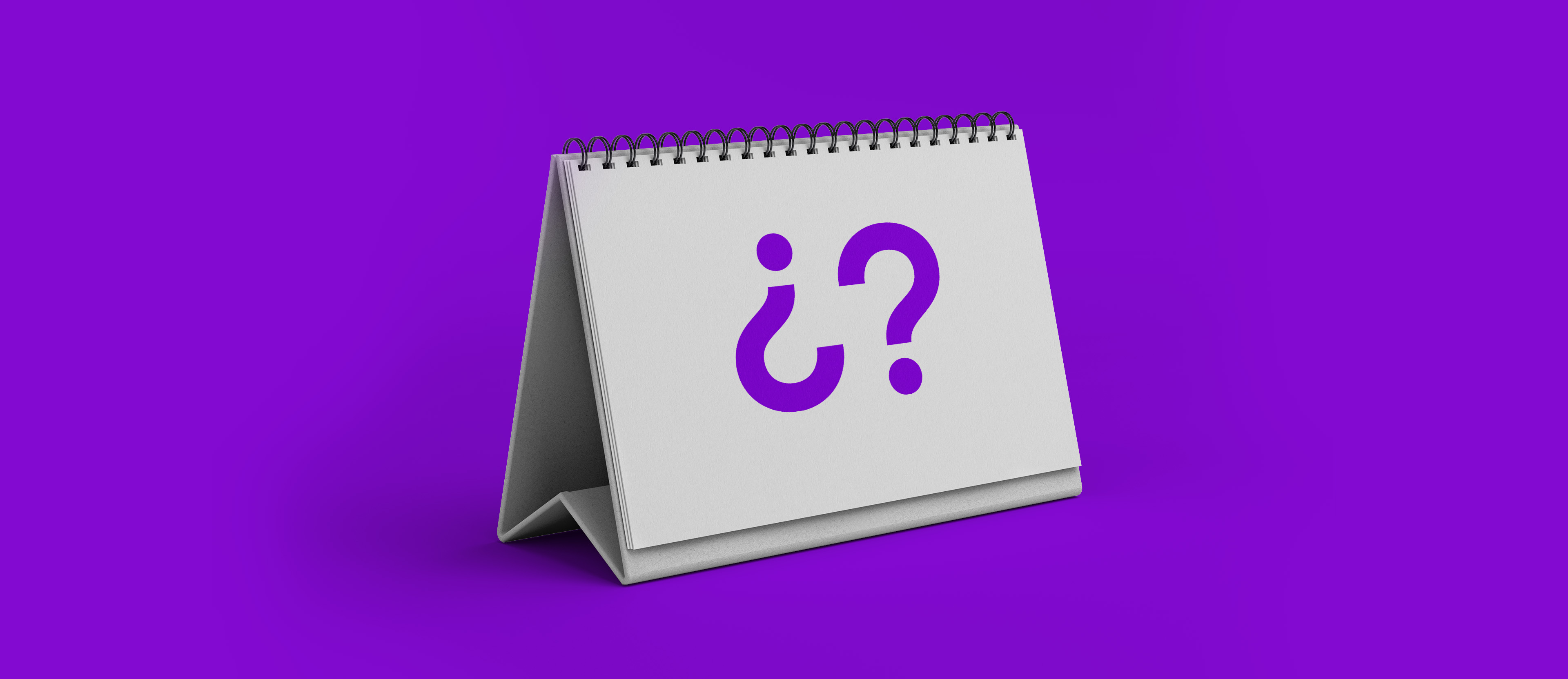 Un calendario de escritorio con las páginas en blanco muestra un par de símbolos de interrogación color morados preguntando cuántos días tengo para pagar después de mi fecha de corte con la tarjeta de crédito nu