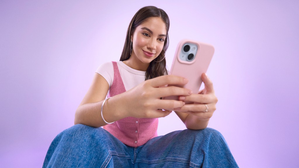 Mujer revisando su celular con atención, en referencia a qué hacer cuando la app Nu está bloqueada.