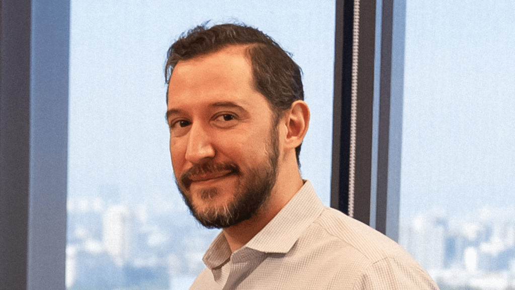 ivan canales director de nu viste una camisa blanca sentado en una oficina con ventanas que muestran una gran vista panorámica en las alturas para anunciar la obtención de la licencia bancaria de nu mexico