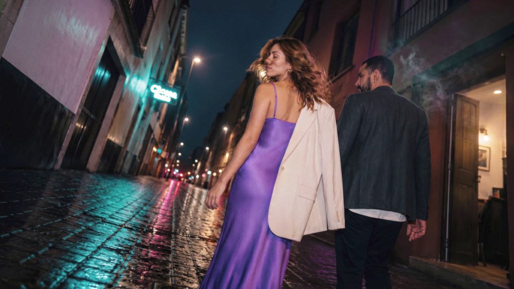 nueva-oferta-prestamo-personal-nu_Header Pareja elegante caminando de noche por una calle iluminada, reflejando la ilusión de recibir una nueva oferta de Préstamo Personal Nu como un nuevo comienzo.