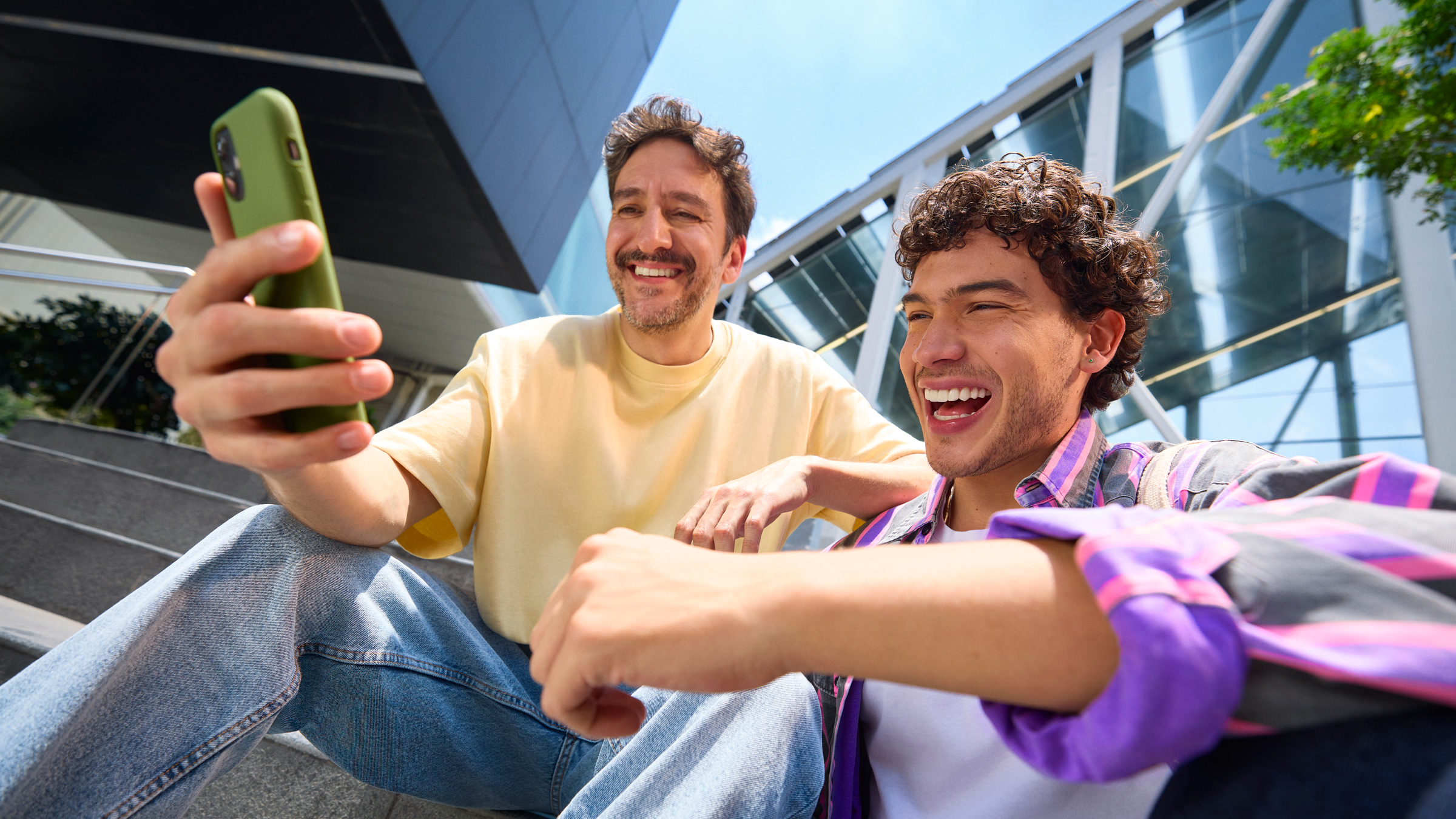 Dos amigos sonriendo mientras revisan el celular, reflejando lo fácil y rápido que es consultar tu crédito disponible en Nu desde la app.