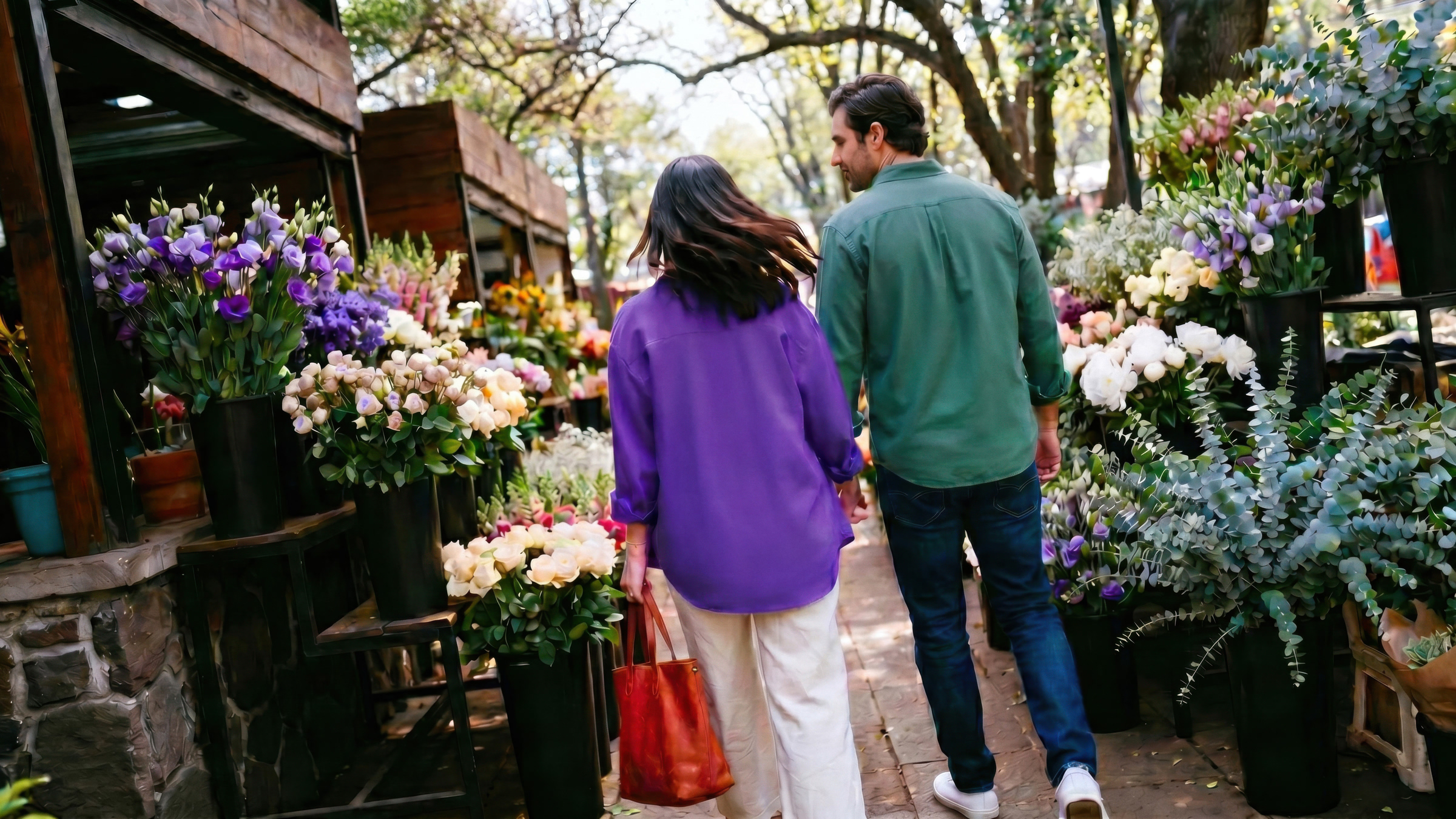 Pareja comprando flores en un mercado local, reflejando la libertad de hacer retiros de efectivo sin tarjeta con Cuenta Nu para tus compras diarias.