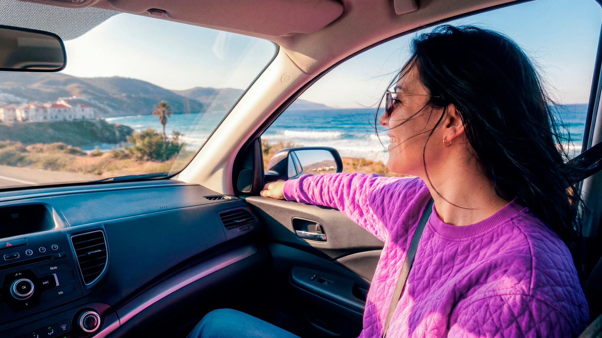 Mujer disfrutando un viaje por la costa con total tranquilidad, reflejando lo fácil que es saber cómo pagar la Tarjeta de Crédito Nu desde la app o SPEI.
