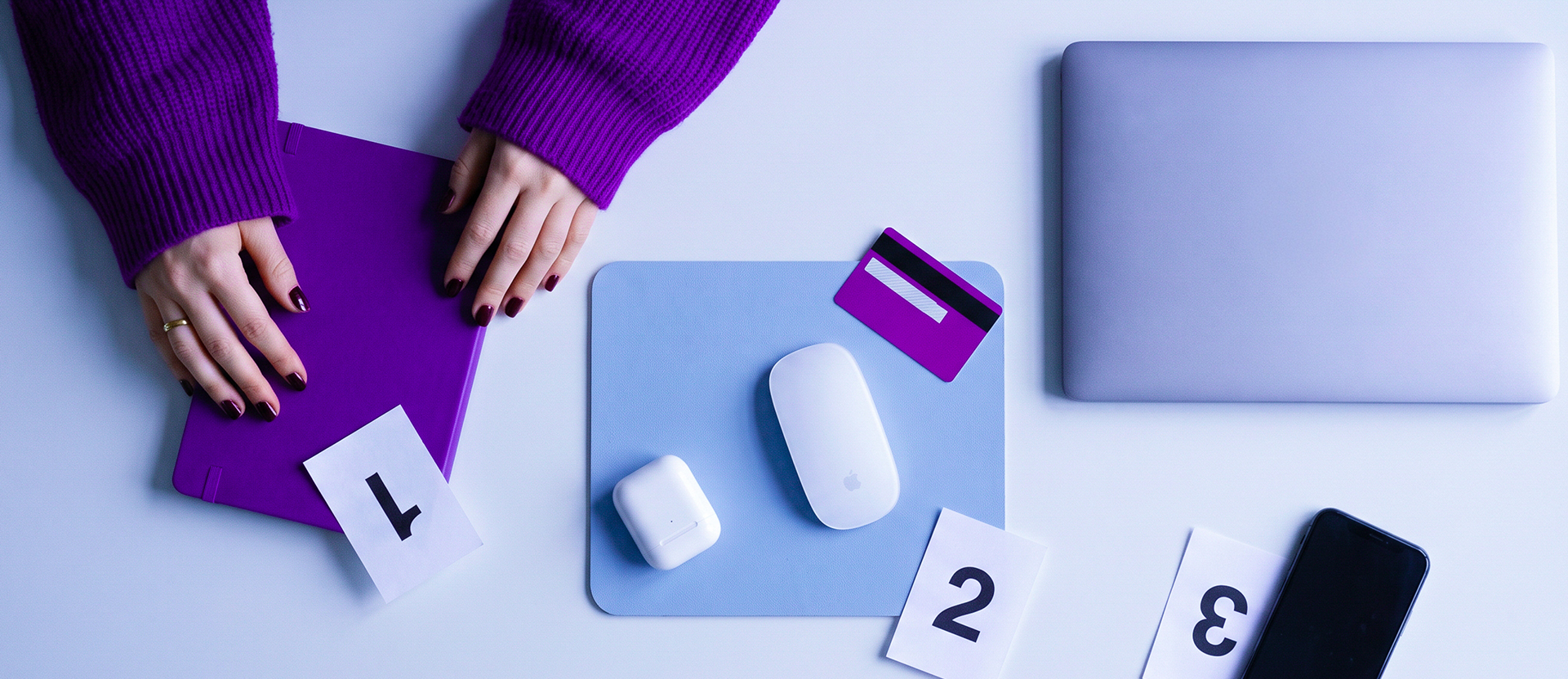 Persona con suéter morado rodeada de múltiples productos y herramientas incluyendo su Tarjeta de Crédito Nu, celular y accesorios, ilustrando cómo hacer de Nu tu banco principal consolidando gasto, ahorro y acceso a crédito.