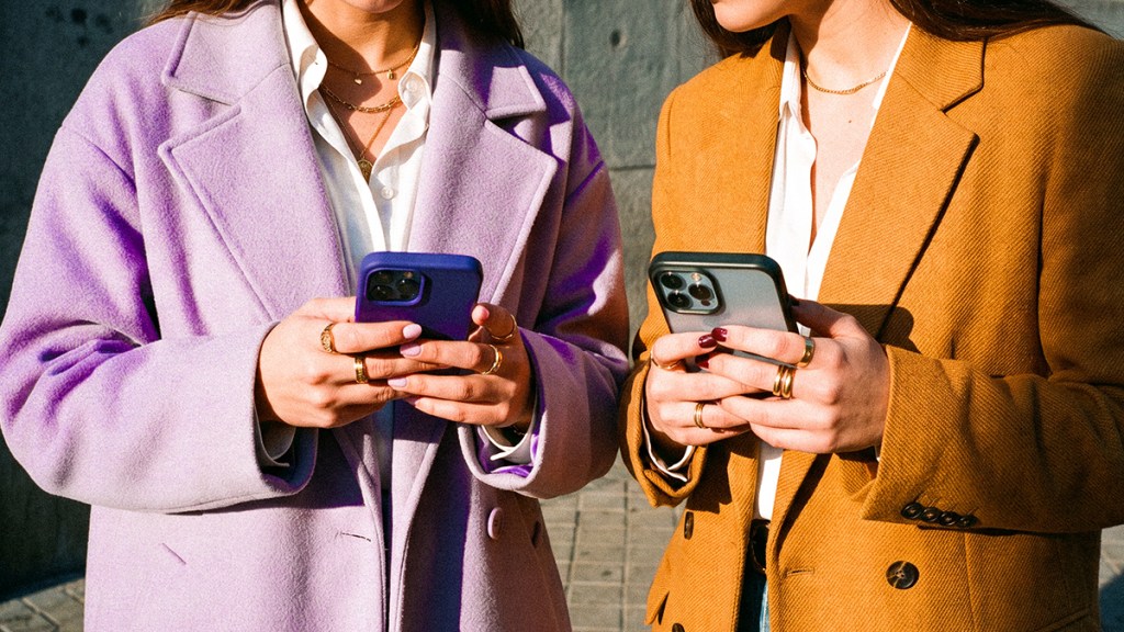 Dos mujeres jóvenes revisando sus celulares con la app Nu, ilustrando qué es Nu: una forma sencilla, moderna y accesible de manejar tus finanzas sin burocracia.