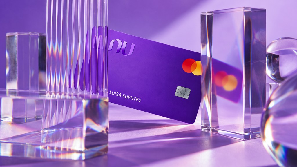 Tarjeta Nu morada entre prismas de cristal que reflejan su imagen, para explicar si es seguro pagar con el celular