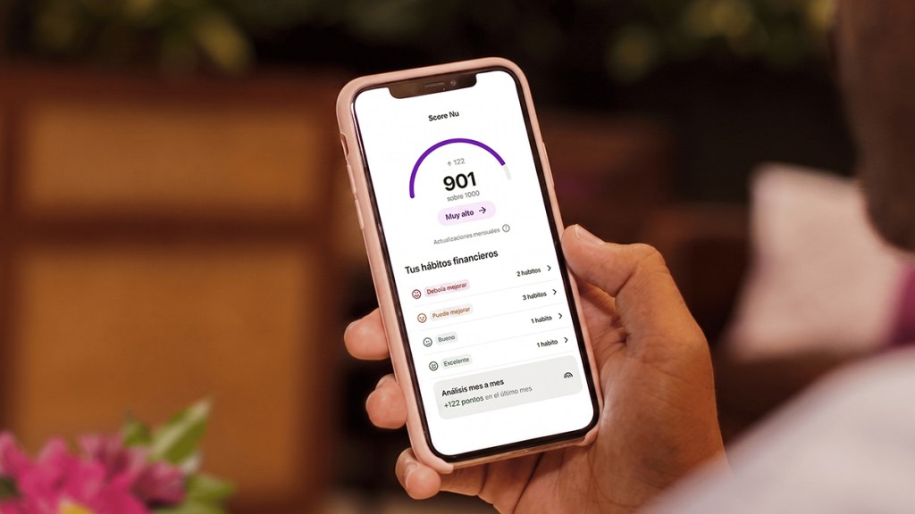 que-es-score-nu_Header Persona consultando Score Nu en su celular, con un nivel muy alto y el detalle de sus hábitos financieros, para entender qué es Score Nu.