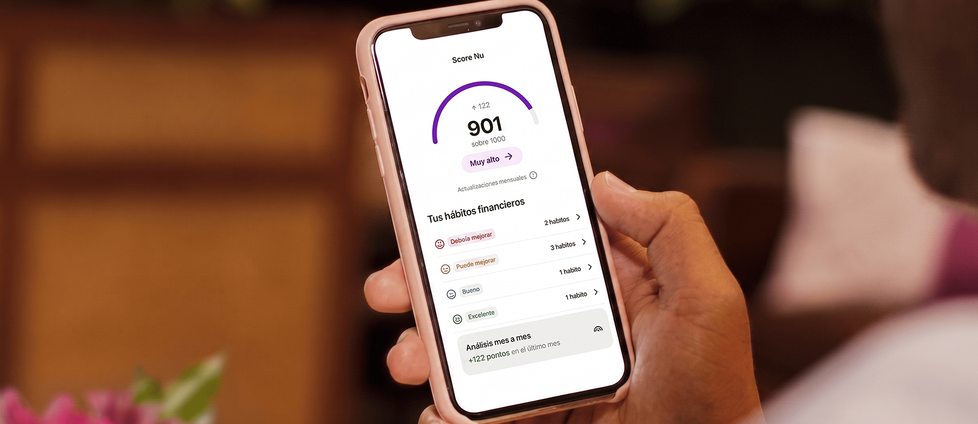 Persona consultando Score Nu en su celular, con un nivel muy alto y el detalle de sus hábitos financieros, para entender qué es Score Nu.