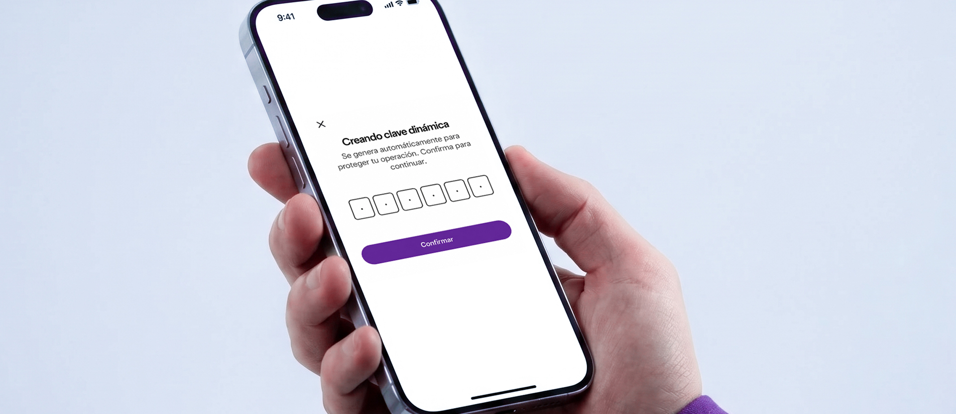 Mano sosteniendo un celular mostrando la pantalla de “Creando clave dinámica” con campos para código de seguridad dinámico y botón morado Confirmar, ilustrando cómo funciona el token de seguridad Nu.